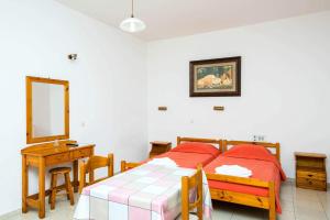 a bedroom with a bed and a table and a mirror at Erato Hotel Apartments in Rethymno