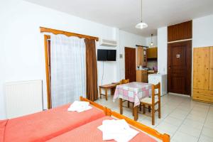 a room with two beds and a table and a kitchen at Erato Hotel Apartments in Rethymno