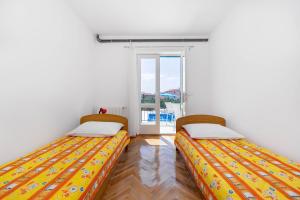 due letti in una stanza con finestra di Neda House a Vodice Altre 21 foto