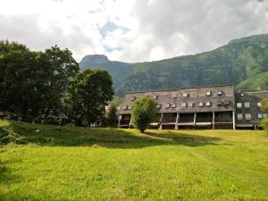 Ein Gebäude auf einem Feld mit Bergen im Hintergrund in der Unterkunft Beti Blu, Kaninska vas in Bovec