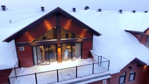 una casa nella neve con le luci accese di Kinipi Spa Nordique & Hebergement a Trois-Rivières