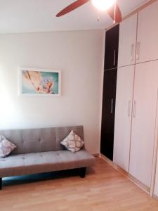 a living room with a couch and a ceiling fan at Sweet Maisonette in Perea