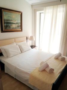 a bedroom with a large white bed with towels on it at Sweet Maisonette in Perea