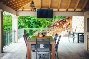 a patio with a table and chairs on a deck at Luxury Villa Borak in Imotski