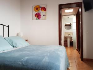 フロンテーラにあるApartamentos Nisdafeの白いベッドルーム(ベッド1台、バスルーム付)