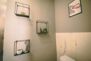 a bathroom with two shelves on the wall and a toilet at 50 Shades of Love in Timişoara
