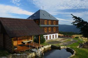 a large house with a pond in front of it at Dvořákova Bouda in Špindlerův Mlýn