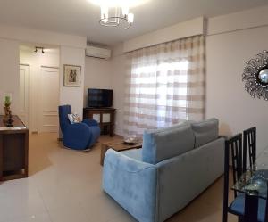 a living room with a blue couch and a tv at AZAHARA 20 in Nerja