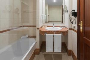 a bathroom with a tub and a sink and a bath tub at Hotel Gran Rey in Valle Gran Rey