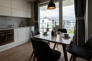 a kitchen and dining room with a table and chairs at Beżowe Love in Olsztyn