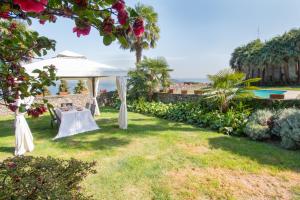 una mesa bajo una tienda blanca en un jardín en Casamariuccia, en Massino Visconti