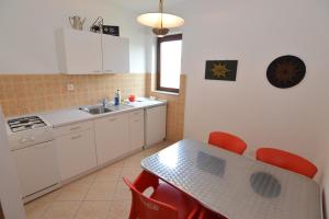 a kitchen with a table with red chairs and a sink at Arthouse Villa Palma in Poreč +100 photos
