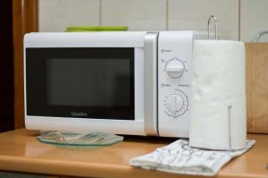 a microwave sitting on a table with a roll of paper towels at Apartman Malina in Karlovac