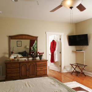Seven Oaks Inn Bed and Breakfast في هاي بوينت: غرفة نوم مع خزانة ومرآة