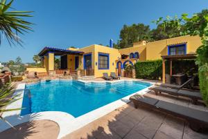 a swimming pool in front of a house at Villa Can Palazon in Ibiza Town