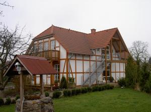 une grande maison avec un toit en métal dans l'établissement Hotel Café am Stift, à Hessisch Oldendorf