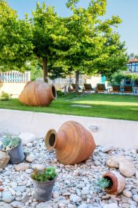 two large wooden vases sitting on a rock garden at Thalassies in Limenaria