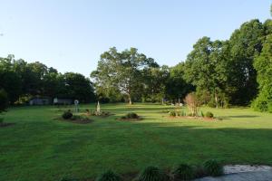 a large green field with trees and bushes at Seven Oaks Inn Bed and Breakfast in High Point