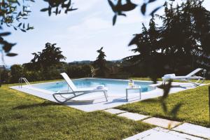 a swimming pool with two lounge chairs in a yard at Moonfrà in Antignano