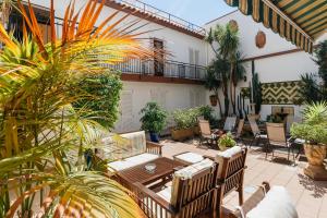 eine Terrasse mit einem Tisch, Stühlen und Pflanzen in der Unterkunft Mallorca Boutique Hotel in Malgrat de Mar