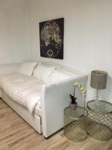 un letto bianco in una stanza con due tavoli di 2 Bedroom Ocean Drive Newly Renovated a Miami Beach