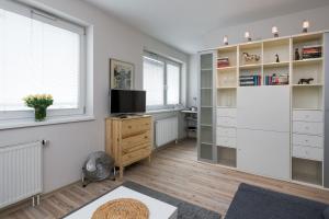 um quarto com paredes brancas, uma televisão e uma secretária em Sunny 1 room apartment with the view over Cracow em Cracóvia