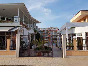 a row of buildings with a gate in a street at Sun City Hotel in Sunny Beach