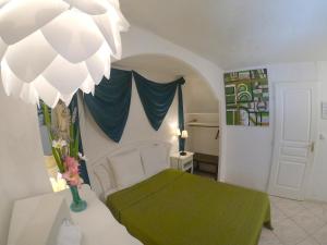 um quarto com uma cama com um cobertor verde em Maison d'hôtes Le Beauséjour em Carcassonne