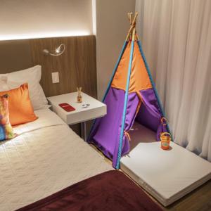 - un lit avec tente à côté d'une table dans l'établissement Rio Hotel by Bourbon Ciudad Del Este, à Ciudad del Este