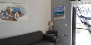 a living room with a couch and a painting of a car at Bousounis Apartments in Chrani