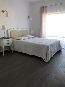 ラゴスにあるVila Guerreiroのベッドルーム1室(ベッド1台、テーブル、窓付)
