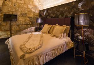 een slaapkamer met een bed en een stenen muur bij HSVHN Hotel Hışvahan in Gaziantep