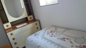 una camera da letto con cassettiera e letto con specchio di Casa Vacanza Chiesa Madre a Canicattì