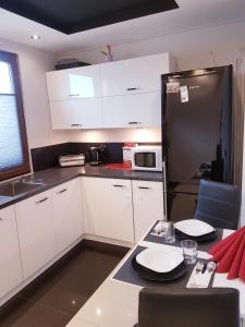 a kitchen with white cabinets and a black refrigerator at Słoneczny in Kielce