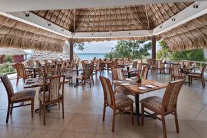 um restaurante com mesas e cadeiras e vista para o oceano em Camino Real Tikal‎ em El Remate