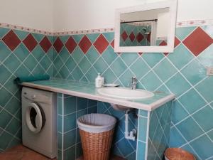 a bathroom with a sink and a washing machine at Michelino in Florinas +28 photos