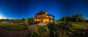 Lielkaibeni في فيتسبييبالغا: منزل خشبي كبير على حقل مع بركة