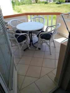 a patio with a table and chairs on a balcony at Apartments Kosec in Vrsi