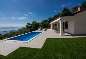 a backyard with a swimming pool and a house at Villa vista sul Quarnero in Matulji