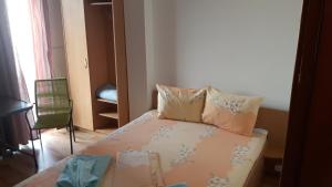 um pequeno quarto com uma cama com almofadas em Vila Cristian em Eforie Nord