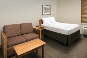 a hotel room with a bed and a couch at WoodSpring Suites Lexington Southeast in Lexington