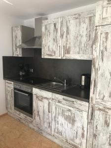 a kitchen with wooden cabinets and a sink and a stove at Blockhaus im Kuckuckswinkel in Schöna