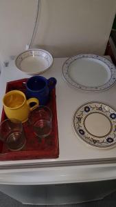 una mesa blanca con platos y tazones. en Cana Cacum en Yerba Buena