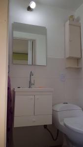 a white bathroom with a sink and a toilet at Cana Cacum in Yerba Buena