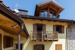 Casa antigua con balcón y persianas de madera en Ca' dei Boieti casa vacanze, en Ronzo Chienis