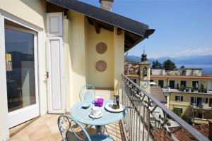 a balcony with a table and chairs on a balcony at Appartamento Ronco in Ghiffa