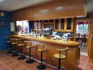 een keuken met een bar met krukken bij Hotel Camargo in Igollo