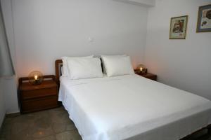 a bedroom with a white bed with two night stands at Feels like home with luxury details in Athens