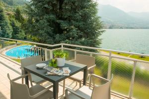 een tafel en stoelen op een balkon met uitzicht op het water bij Casa Cristini in Marone