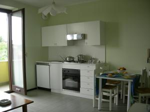 a kitchen with a stove and a table in it at Albergo Residence Isotta in Veruno